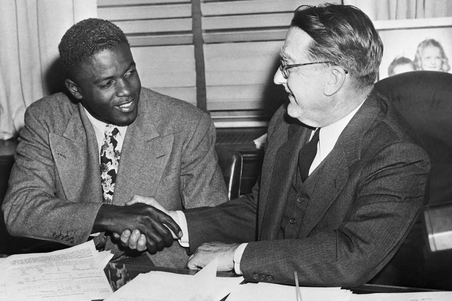 جکی رابینسون و رئیس داجرز، شعبه ریکی، پس از امضای قرارداد رابینسون در سال 1948، دست می دهند.