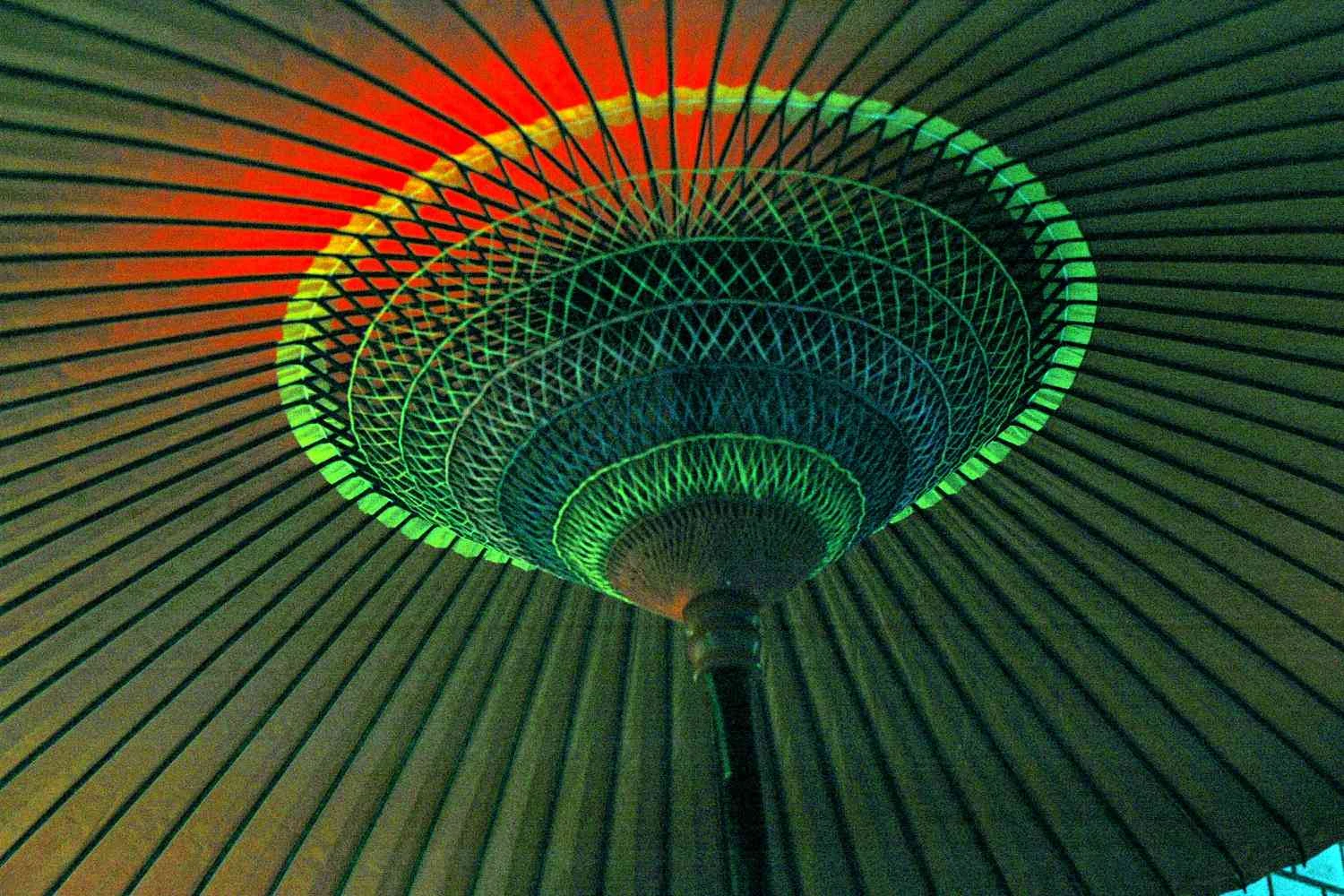 چتر آفتابی سنتی قرمز ژاپنی با پایه‌های چوبی ظریف، پوست حساس را از نور خورشید محافظت می‌کند و در طول 4400 سال تکامل یافته است