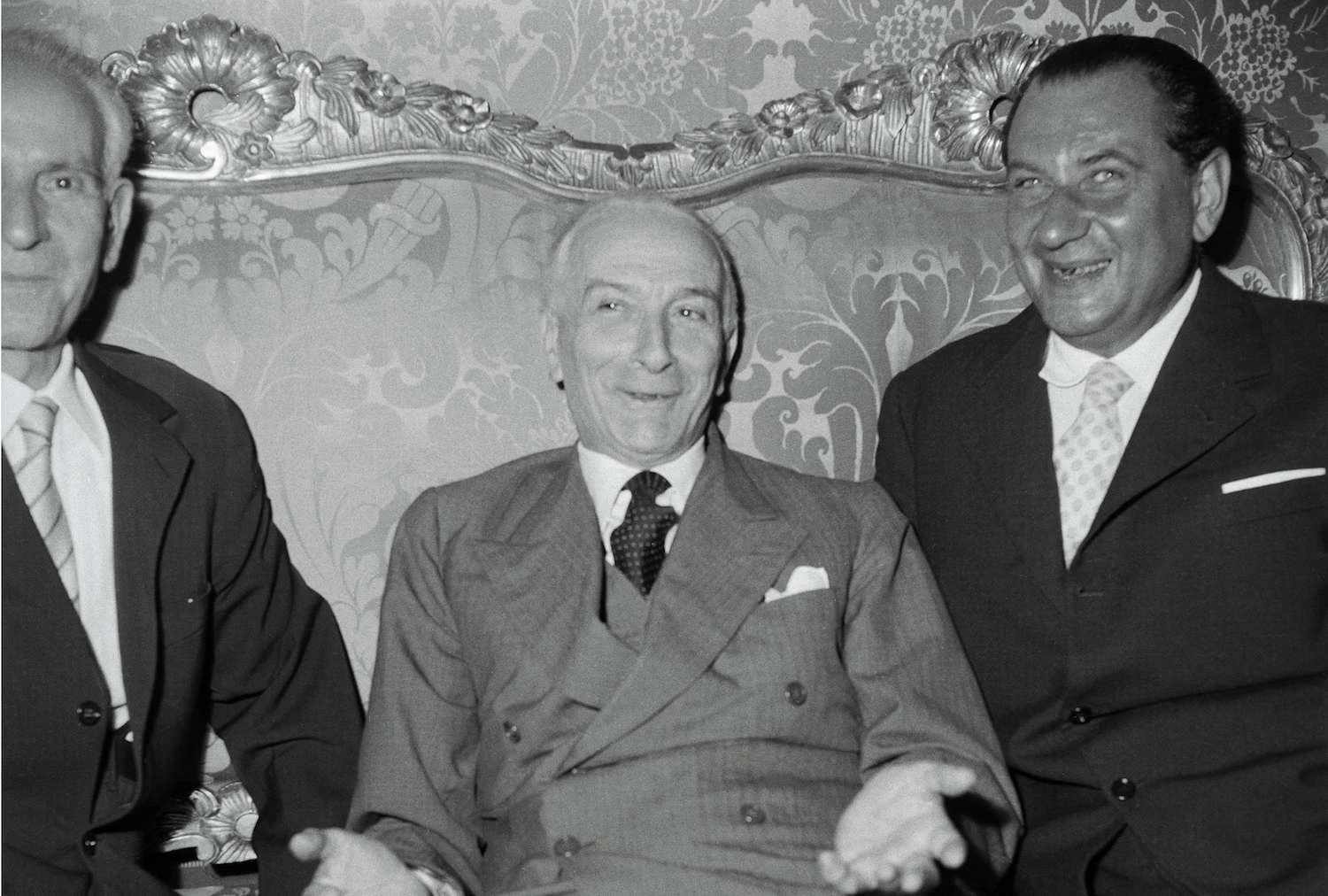 عکس رئیس جمهور آنتونیو سگنی که روی مبل بین دو مرد دیگر نشسته است.